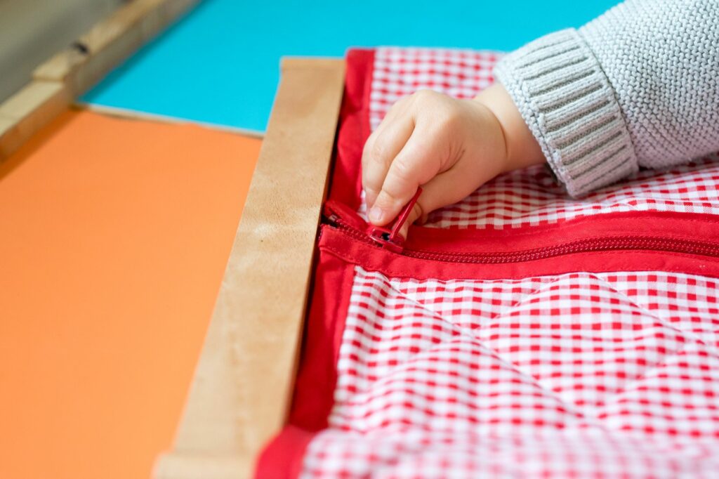 main d'un enfant, manipulant une fermeture de gilet.